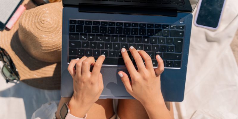 Woman using her computer on the beach